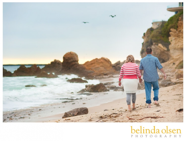 engaged couple walking on the California beach